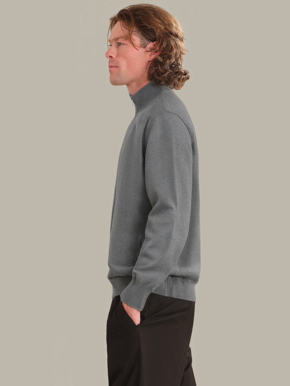 Man wearing a gray sweater against a plain background