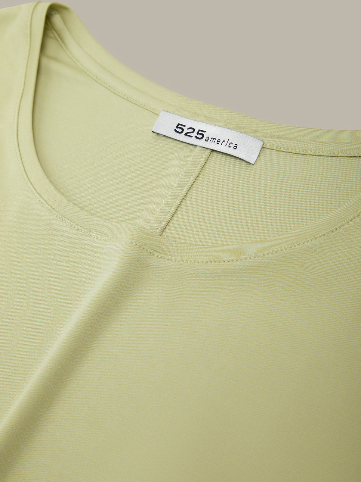 Light green tank top with a brand label on a beige background