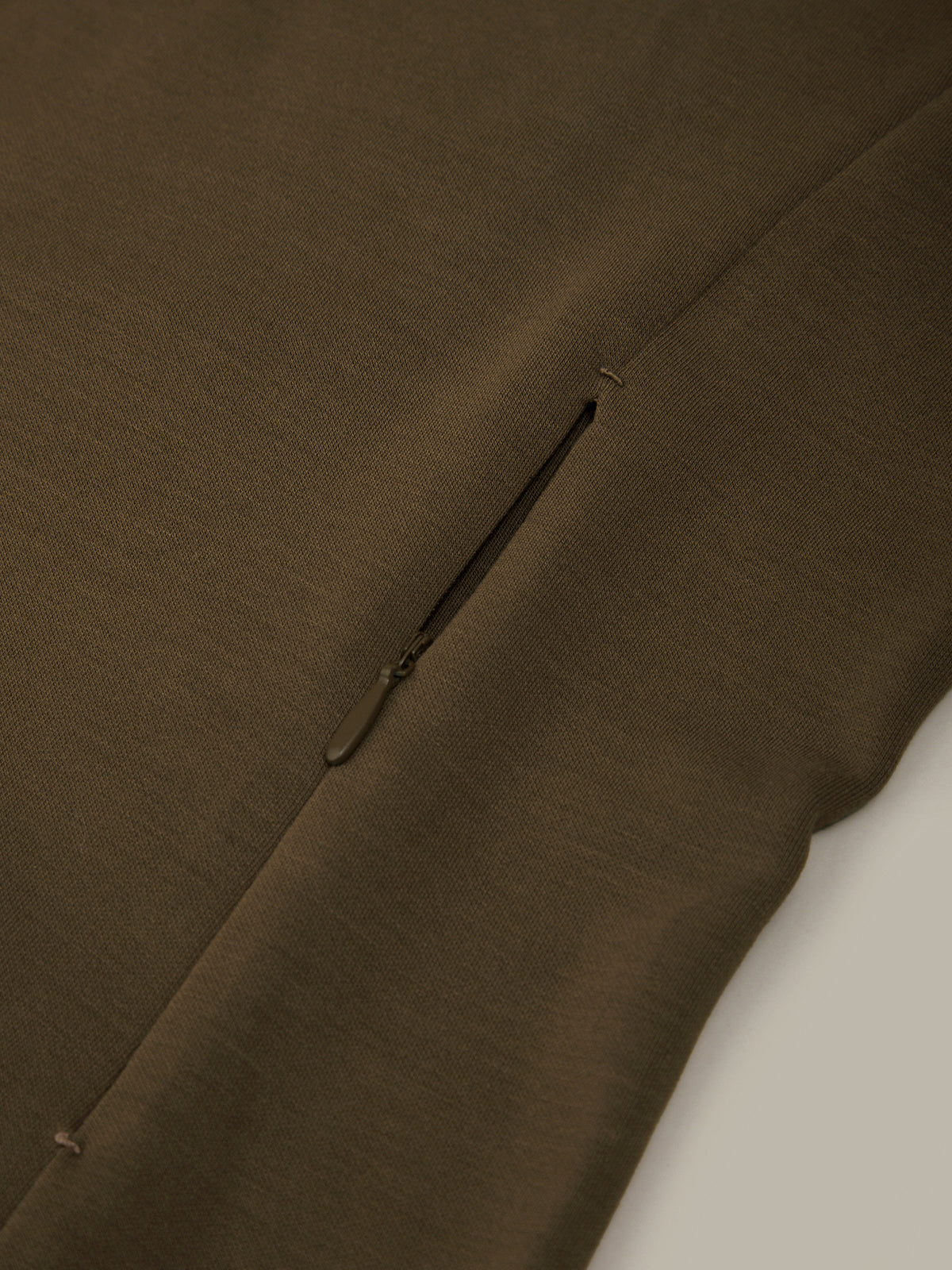 Close-up of a brown fabric with a seam on a white background