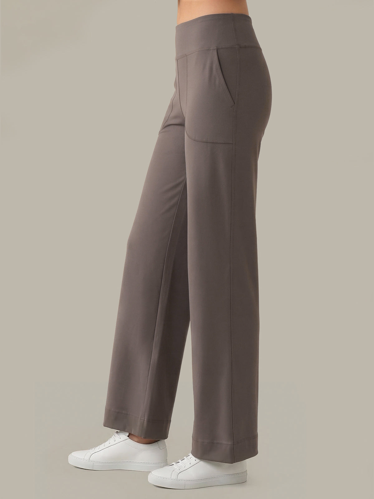 Grey pants worn by a person on a beige background