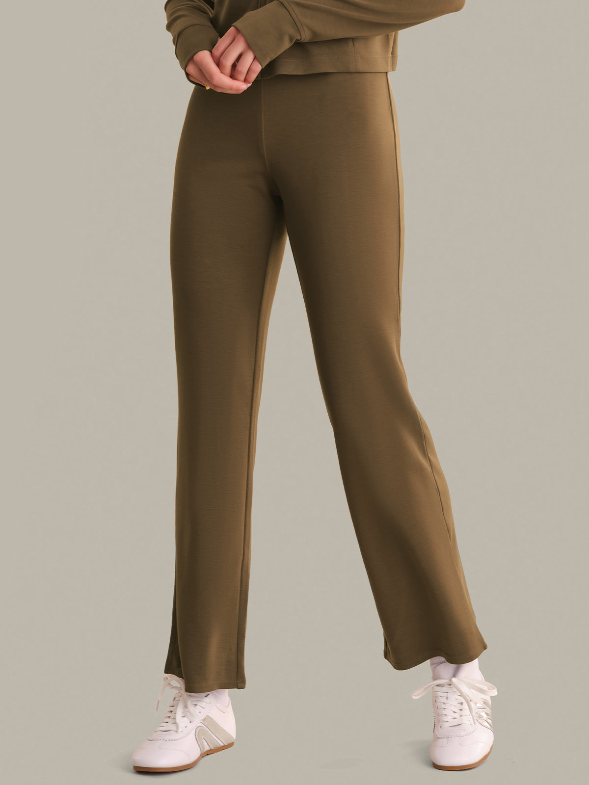 Person wearing brown pants and a matching top on a light gray background