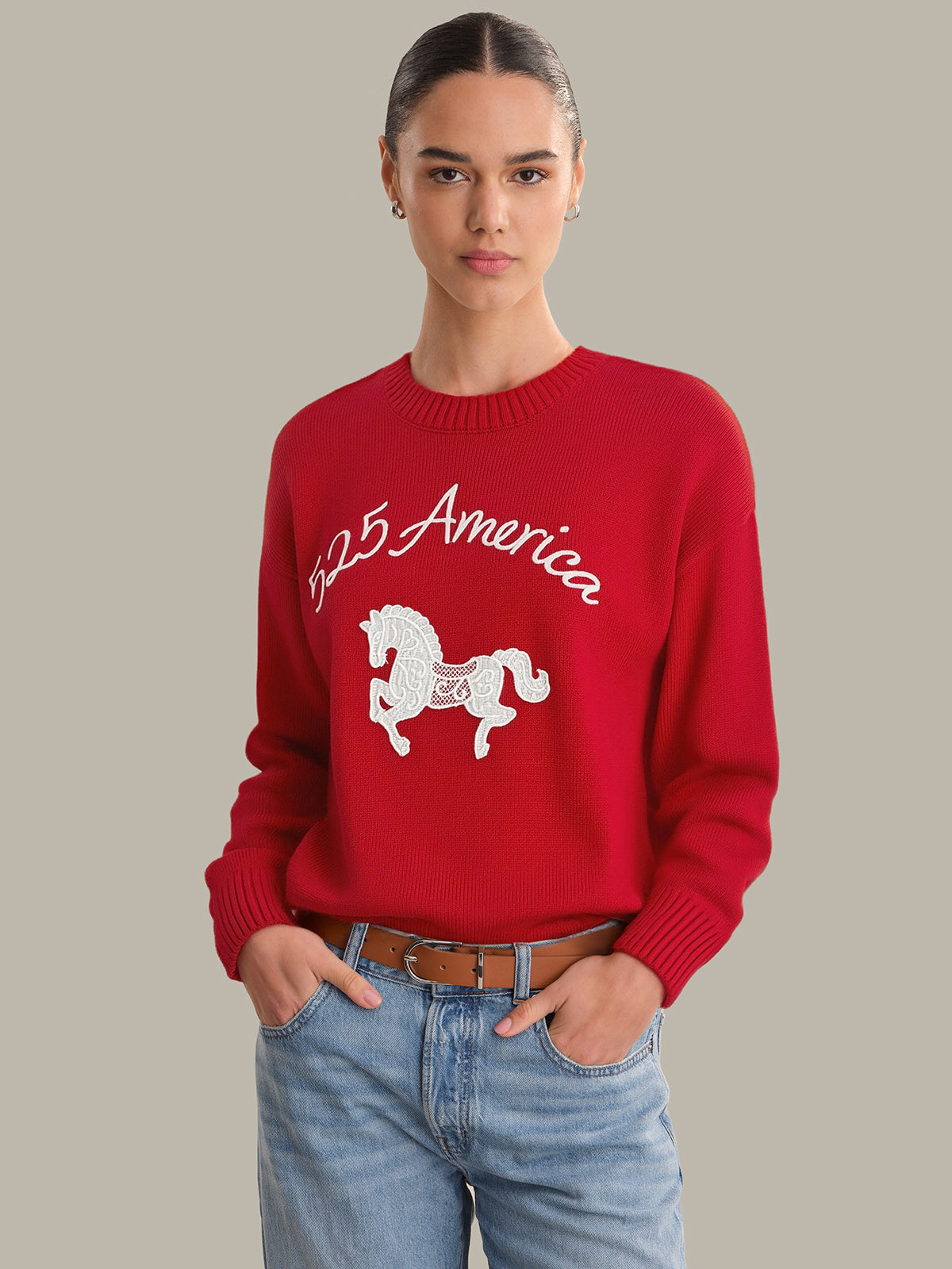Person wearing a red sweater with a horse graphic and '1925 America' text on a beige background