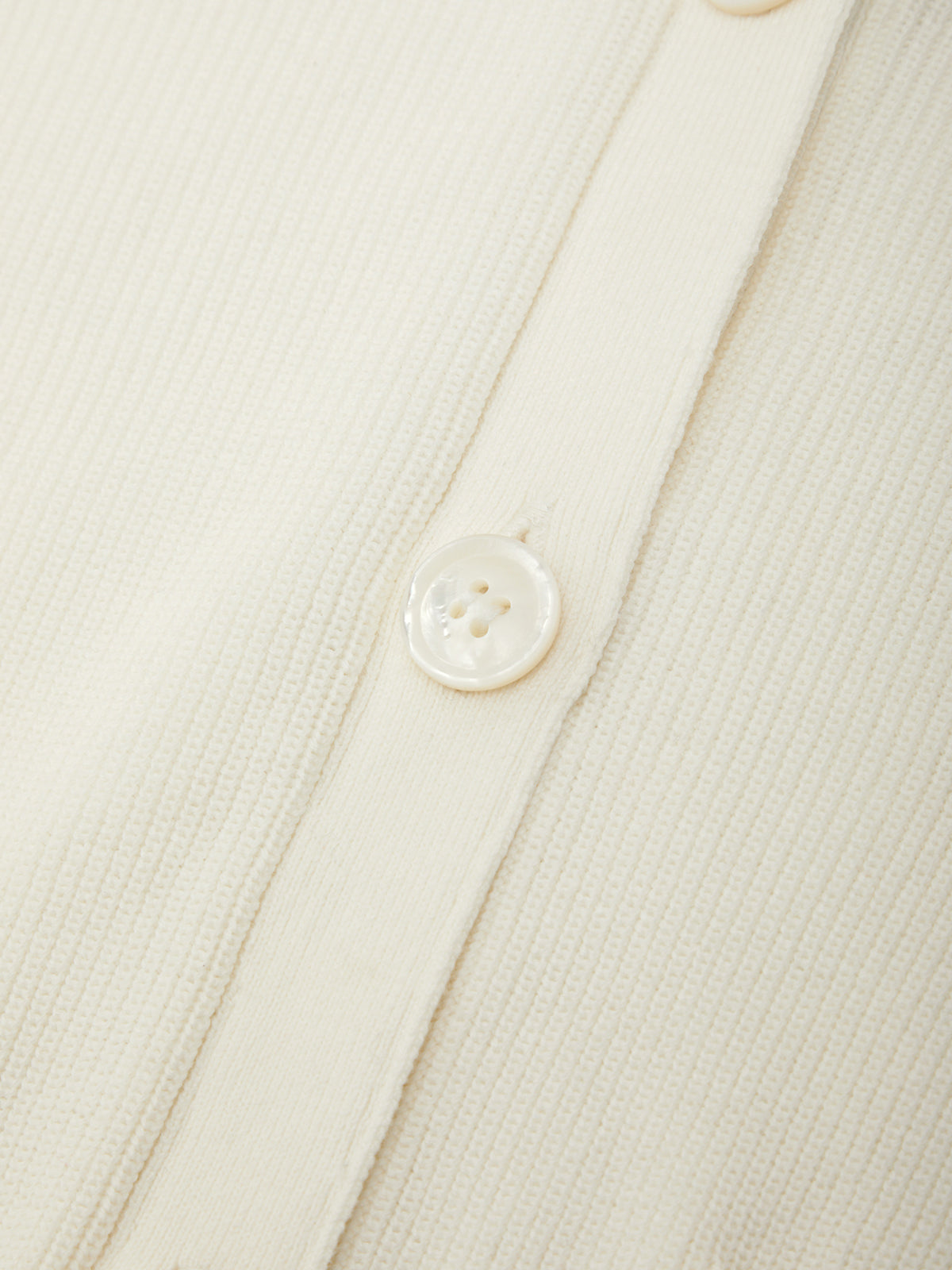 Close-up of a button on a textured beige fabric