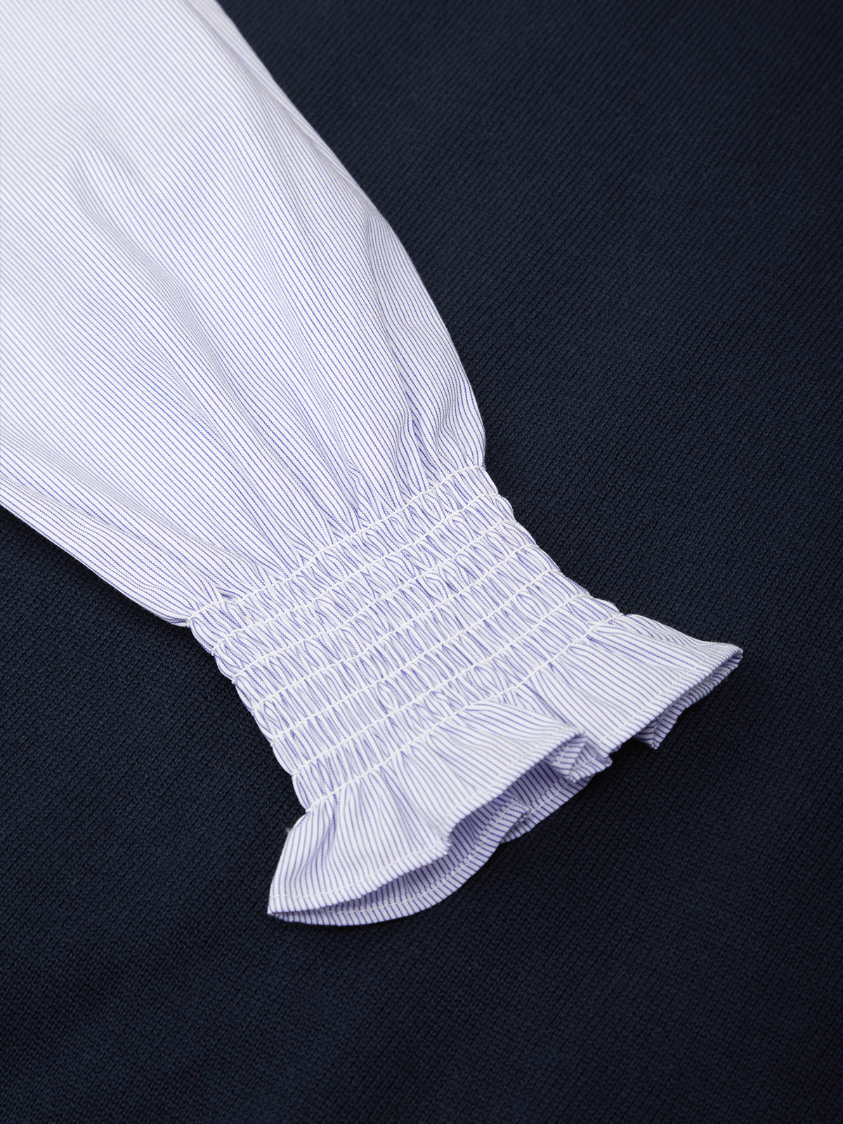 Close-up of a white blouse with ruffled sleeves on a black background