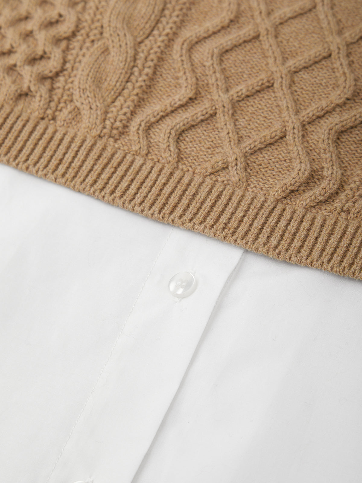 Close-up of a brown knitted sweater with a textured pattern on a white background