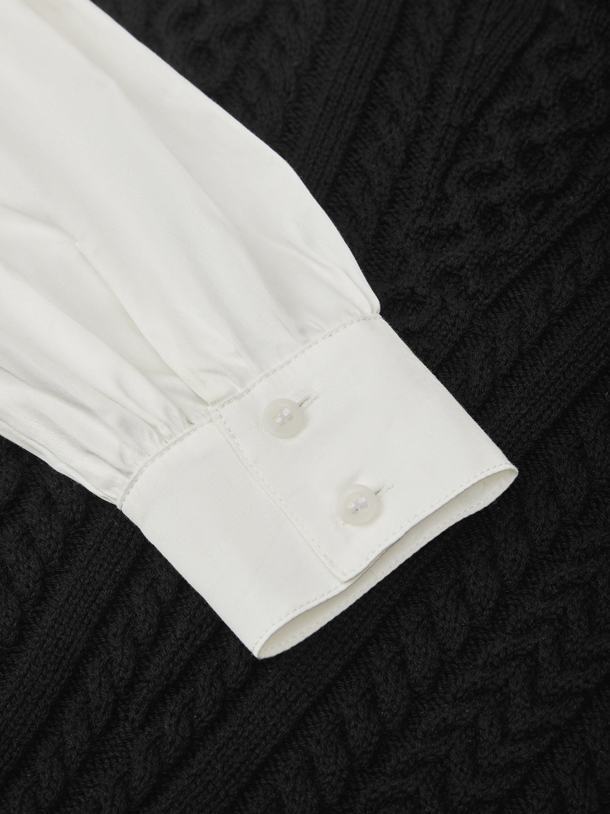 Close-up of a white shirt collar with buttons on a black textured background