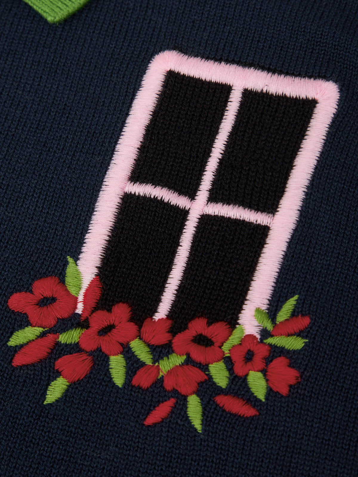 Embroidered design of a window with red flowers on a dark background