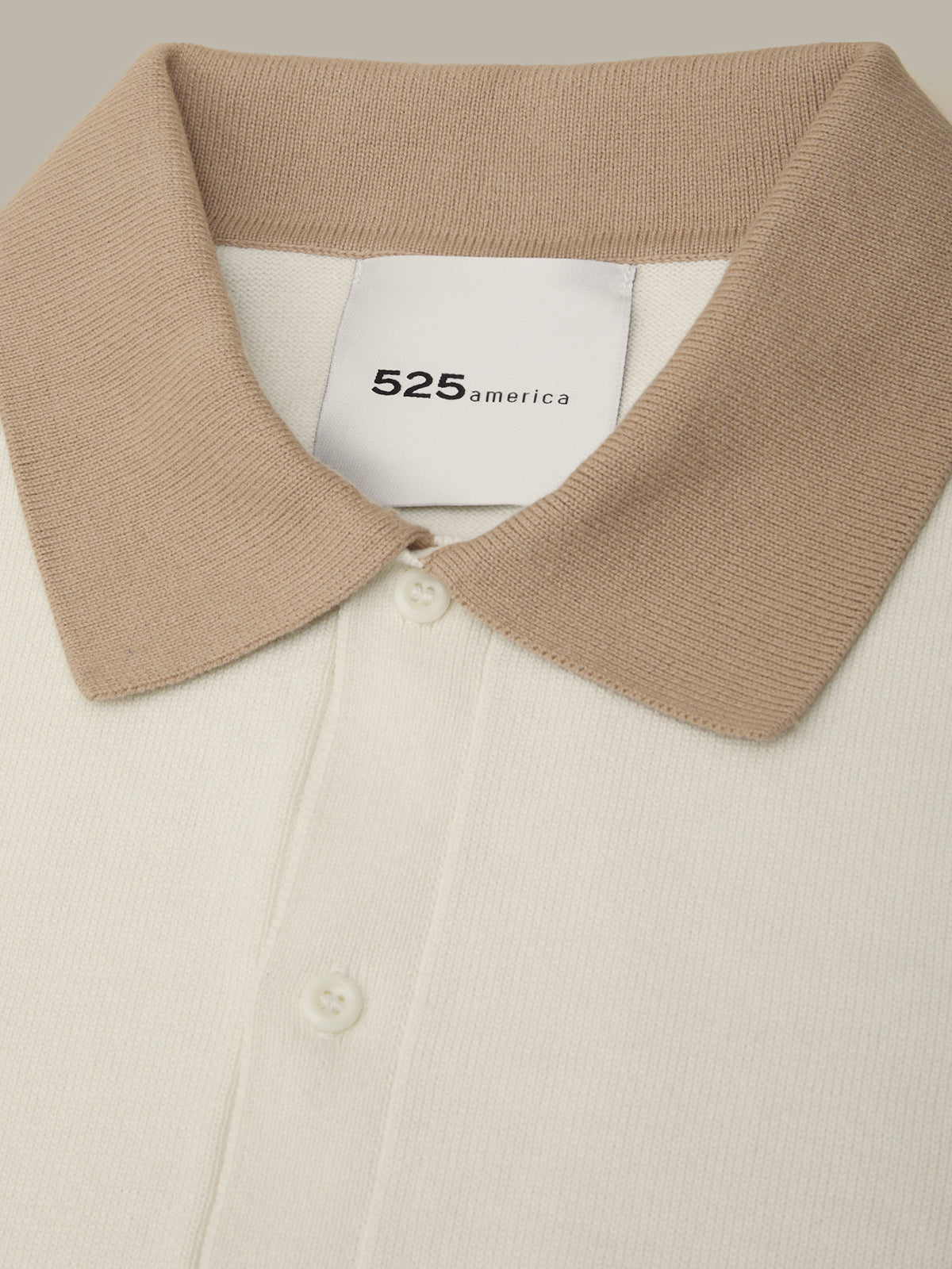 Close-up of a beige collar with a visible brand label on a light background