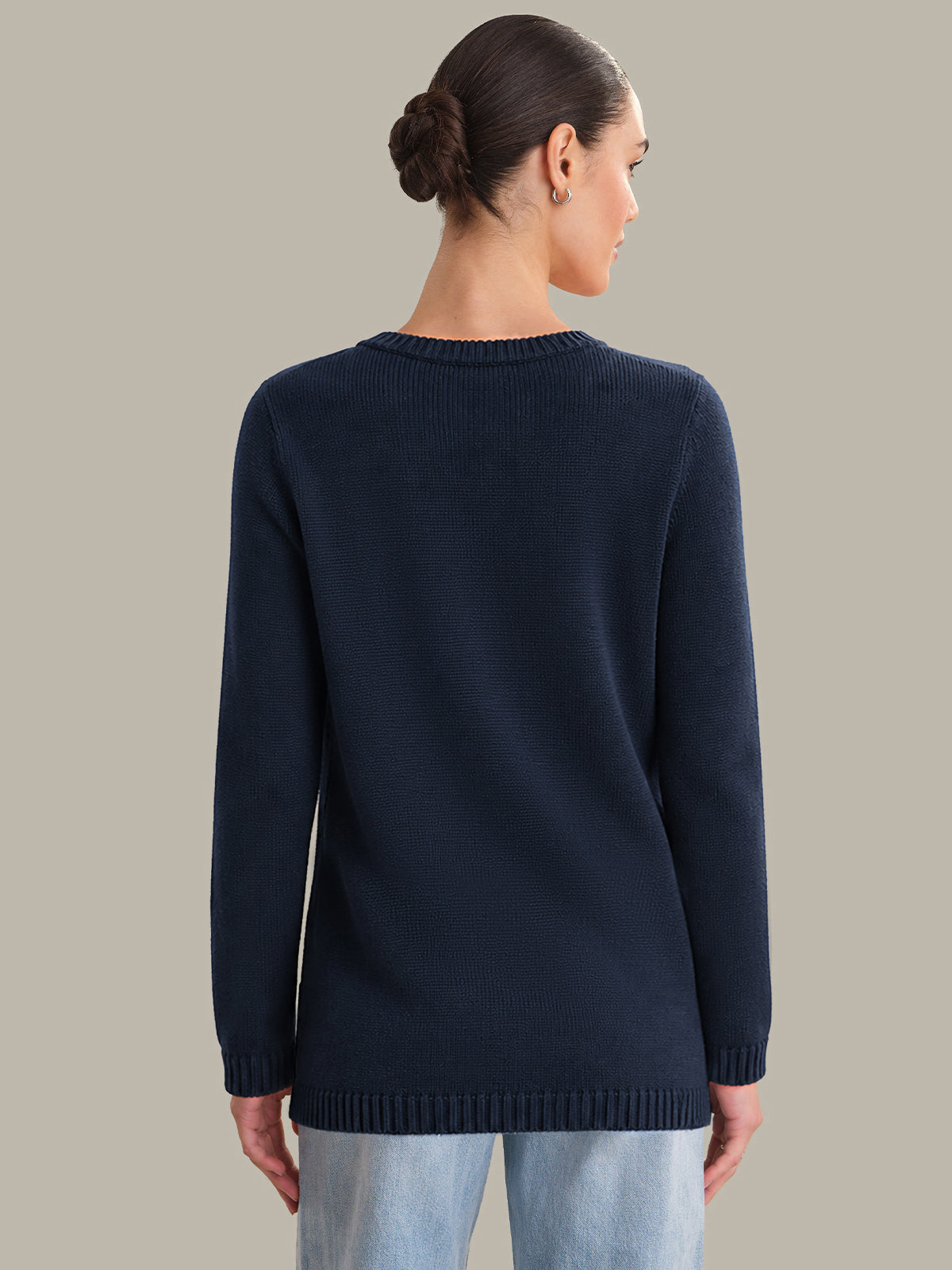 Person wearing a navy sweater on a plain background