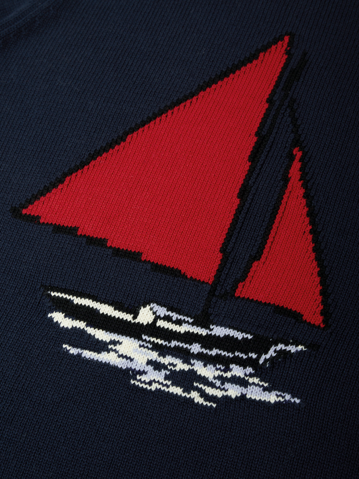Navy blue sock with a red sailboat design on a dark background