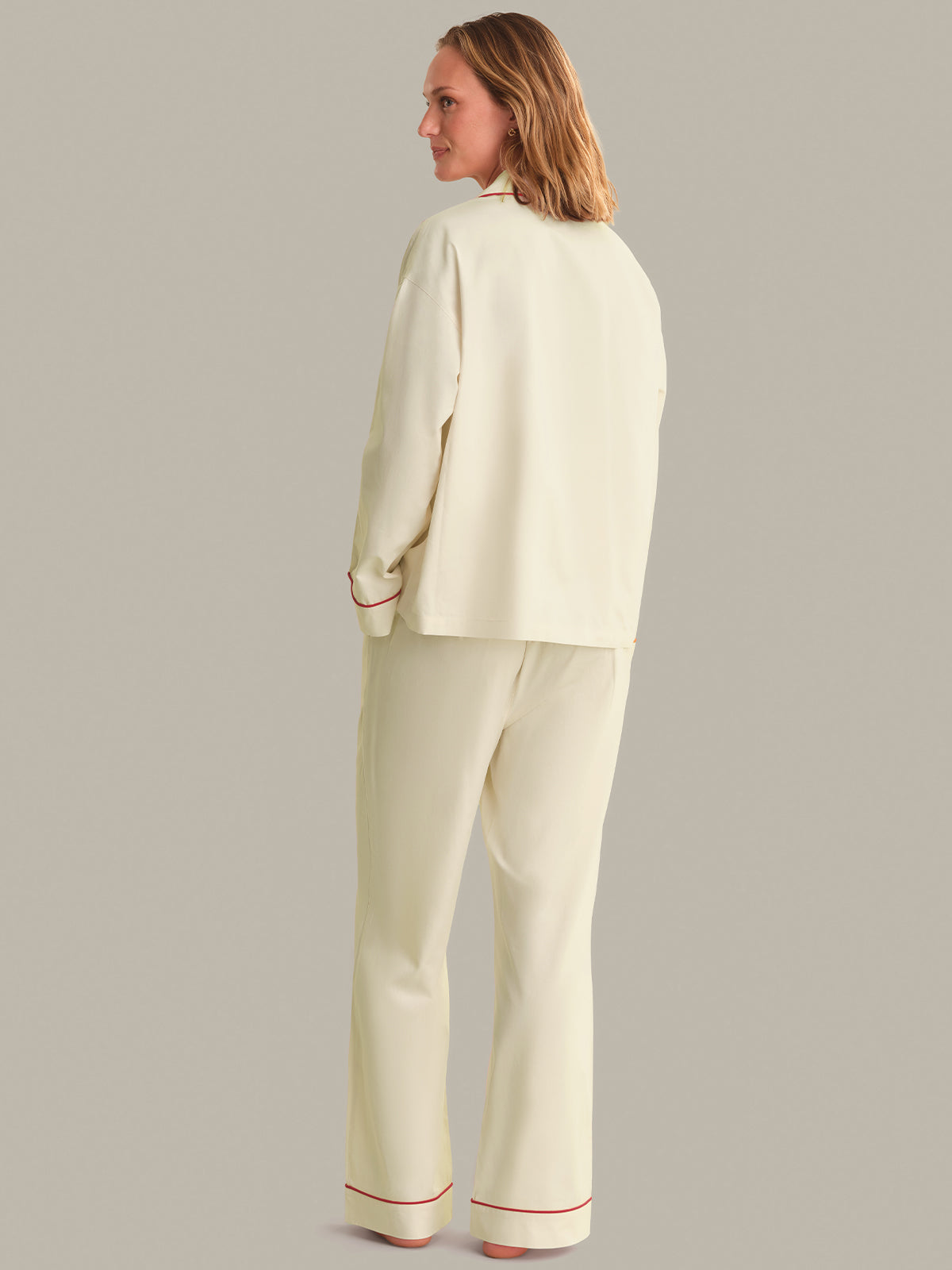 Woman wearing a light-colored pajama set against a plain background