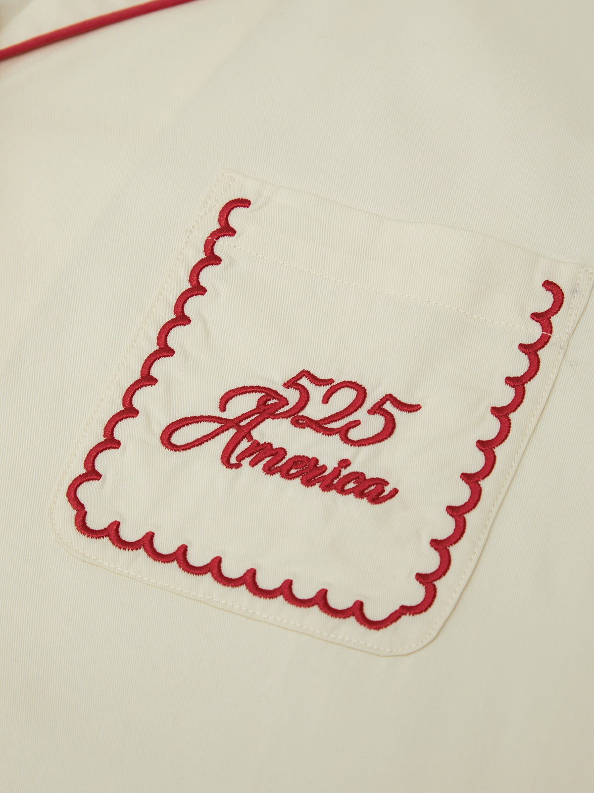 Embroidered red design on a white background