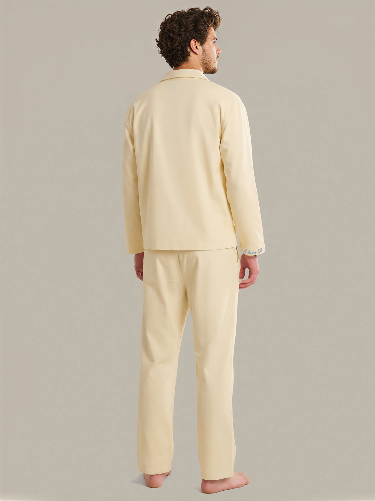 Man wearing a light yellow pajama set against a plain background