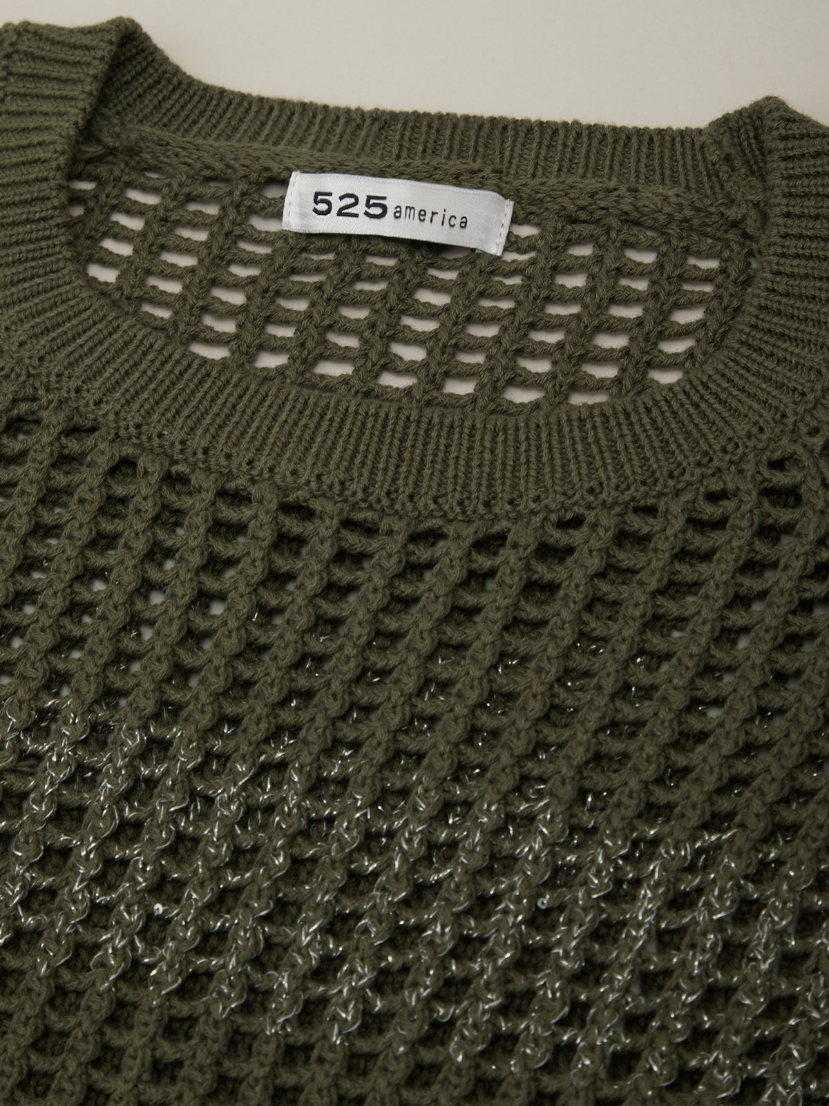 Green knitted sweater with a brand label on a white background