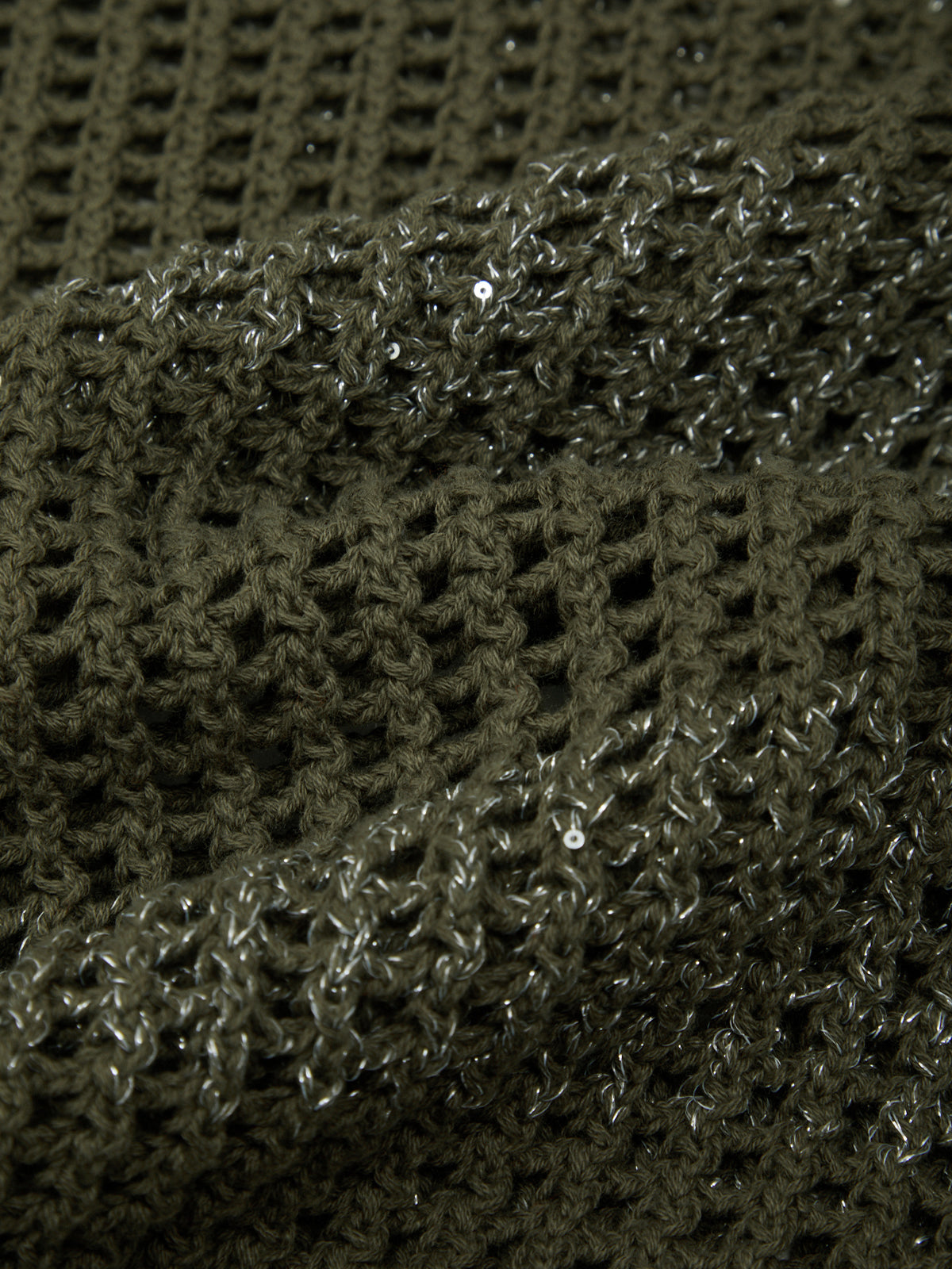 Close-up of a textured green fabric with a diamond pattern