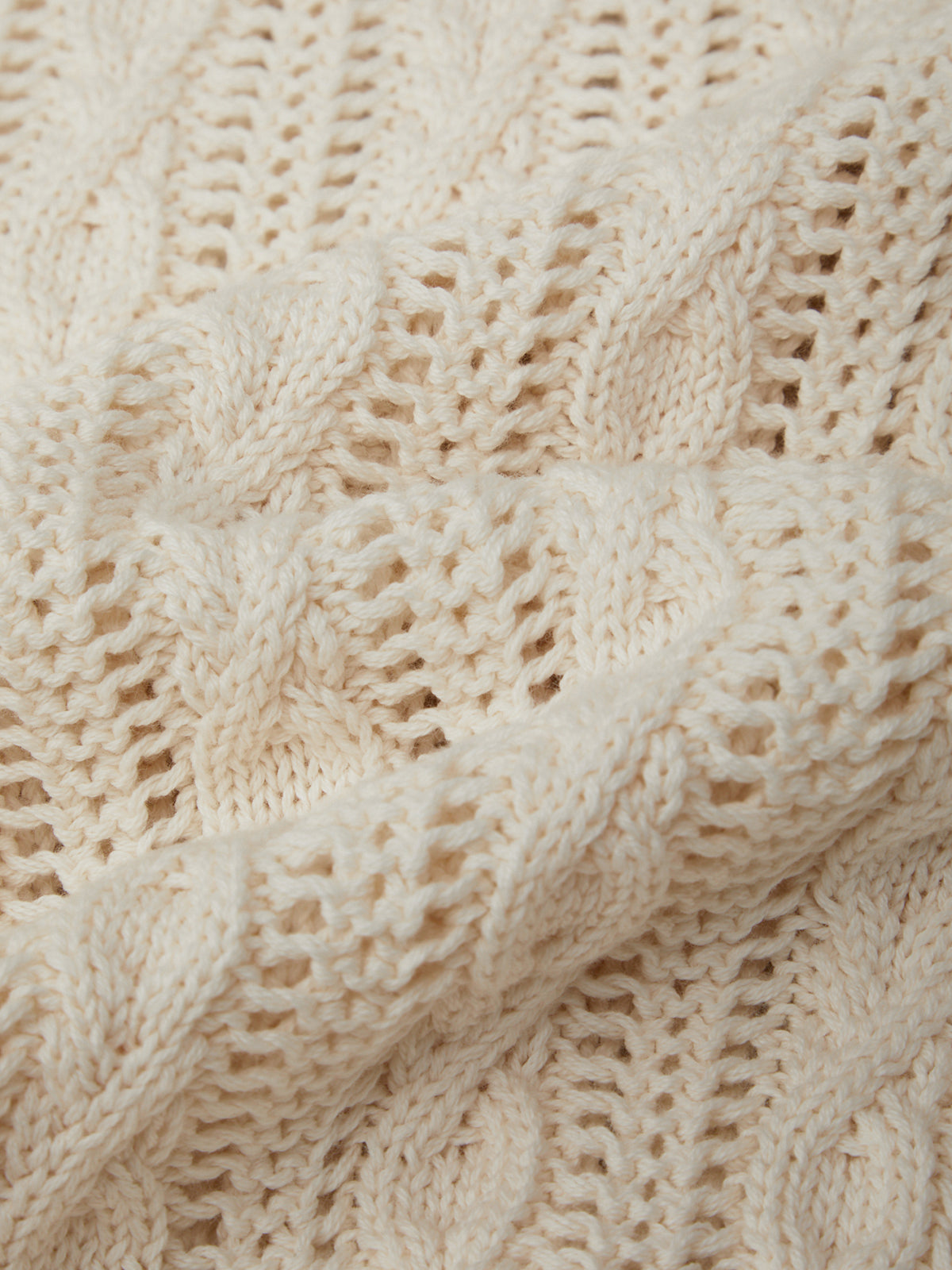 Close-up of a beige knitted fabric with a textured pattern