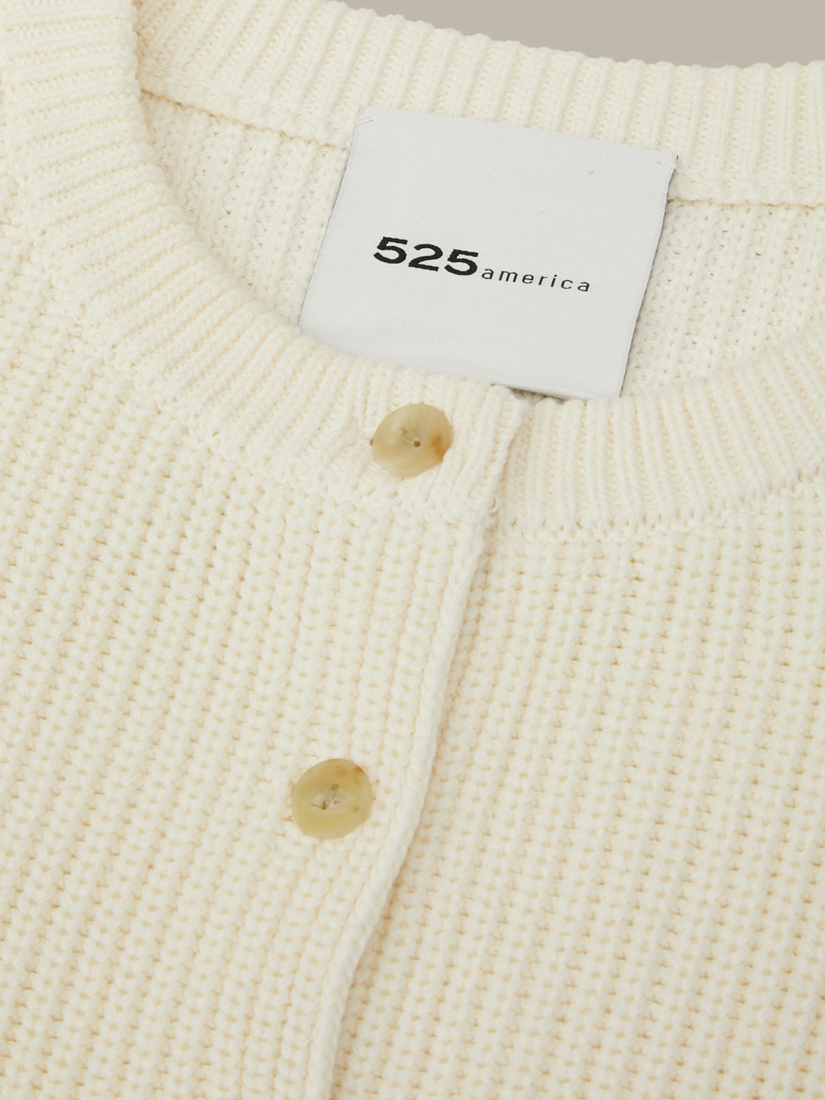Close-up of a cream-colored textured garment with a '525 America' label.
