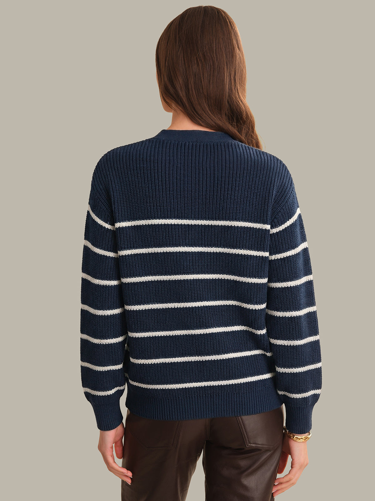 Person wearing a navy and white striped sweater on a plain background