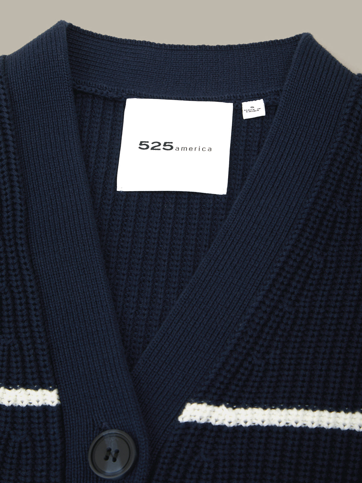 Navy cardigan with a visible brand label on a neutral background