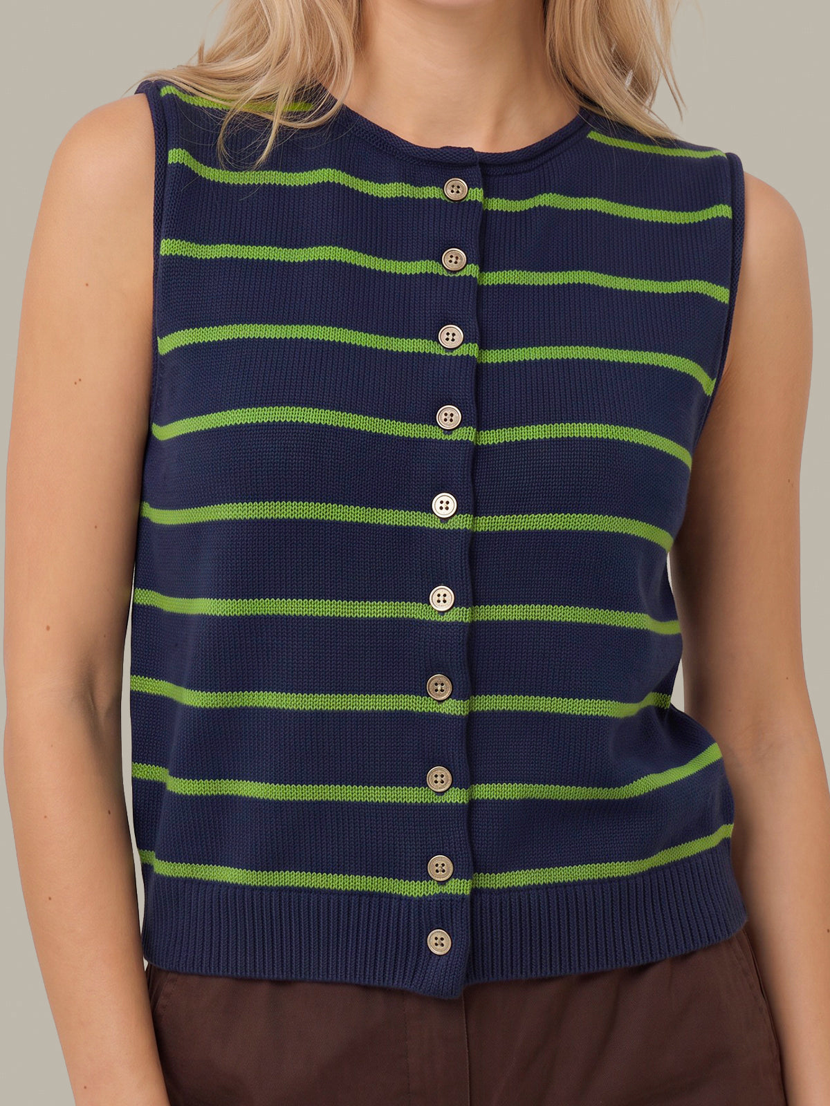 A sleeveless ribbed knit top with horizontal lime green stripes on a navy blue base, featuring a front button closure. The top is shown on a model against a solid neutral background.