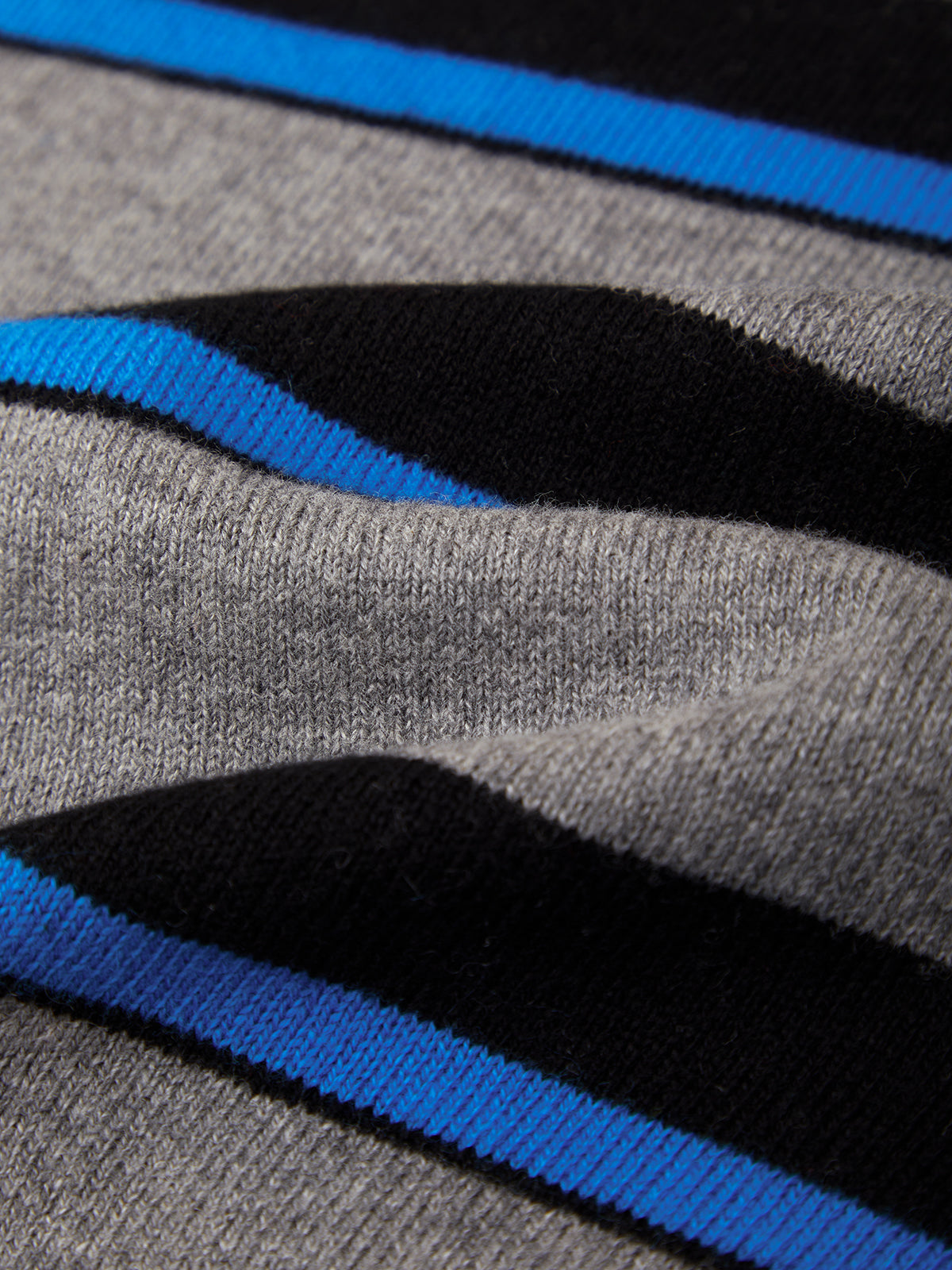Close-up of a knit fabric with horizontal stripes in gray, black, and bright blue.