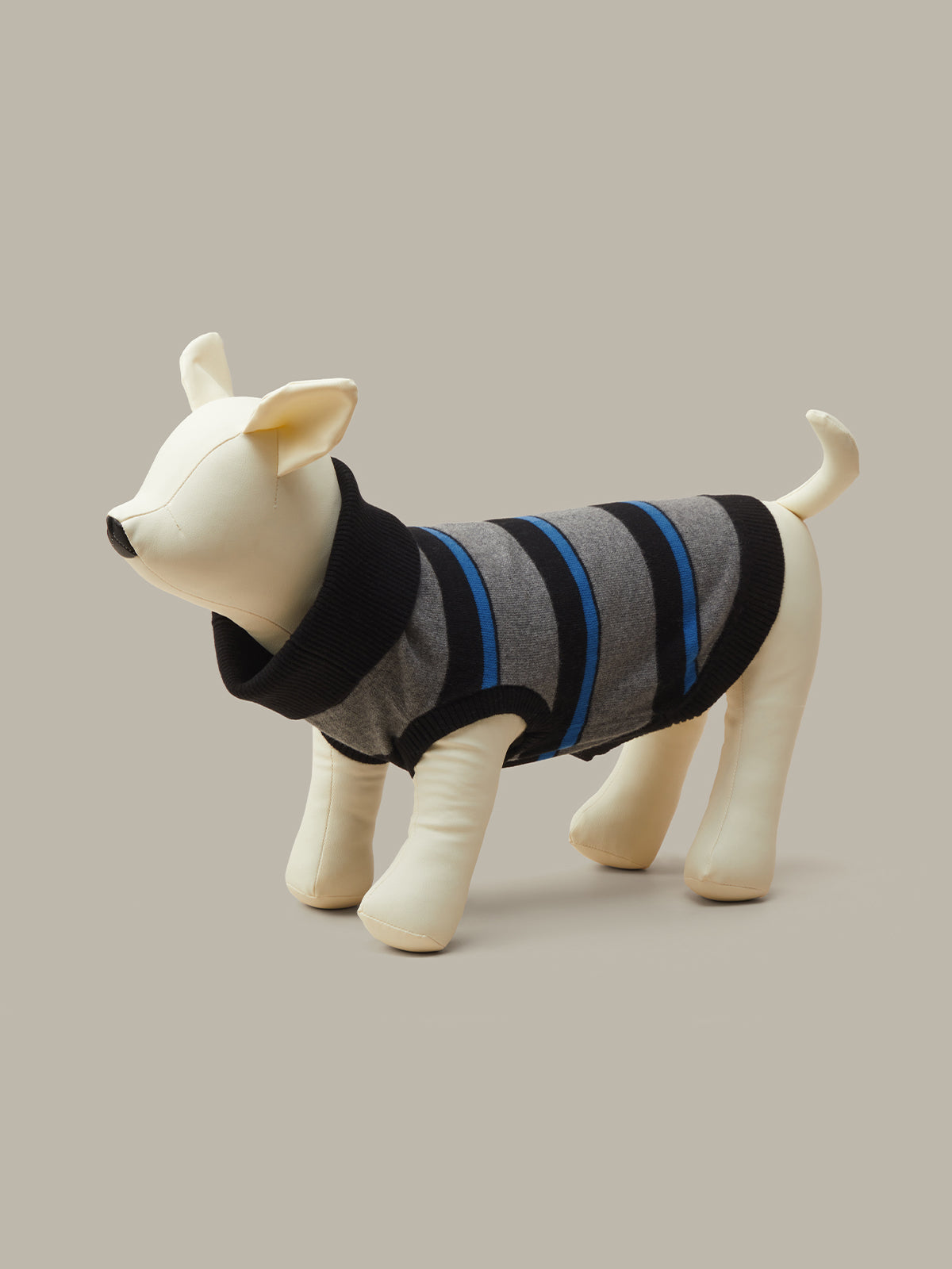 A cream-colored dog mannequin wearing a gray knit pet sweater with black and blue stripes, set against a solid taupe background.