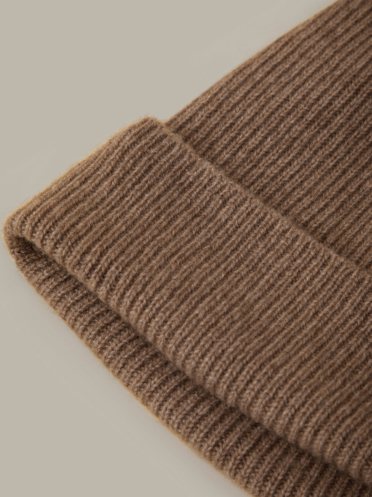 Close-up of a brown knitted fabric on a beige background