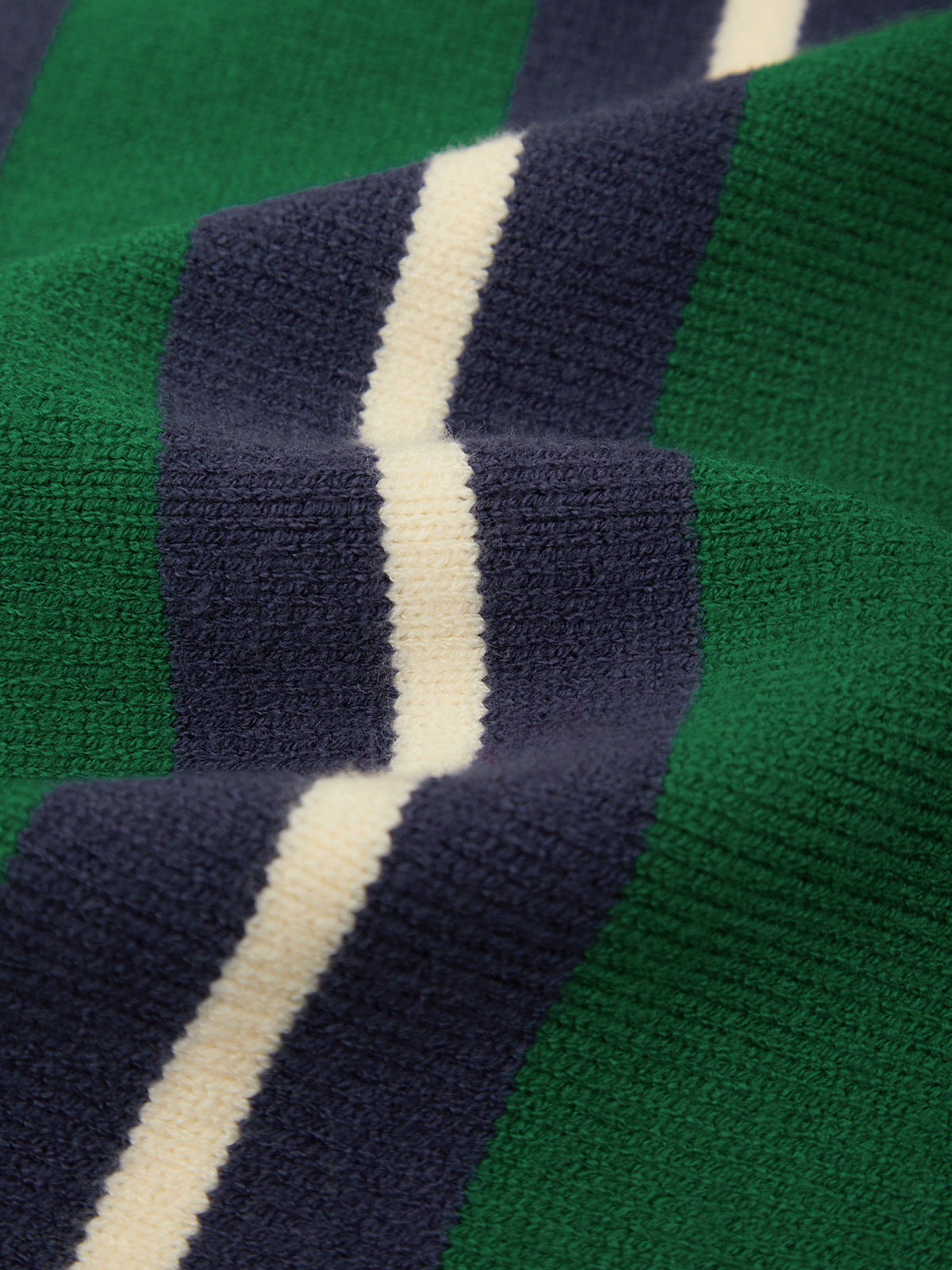 Close-up of a ribbed knit fabric with vertical stripes in green, navy blue, and off-white.