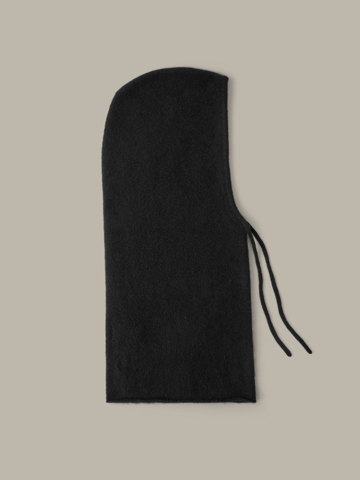 Black hooded garment on a beige background