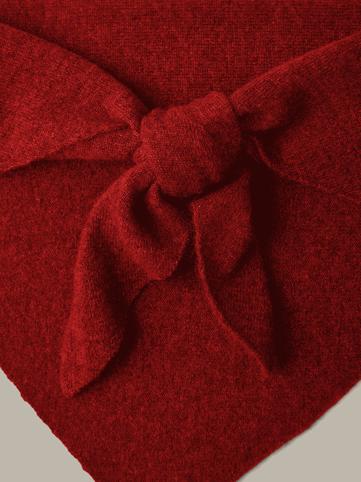 Close-up of a red fabric with a bow on a neutral background