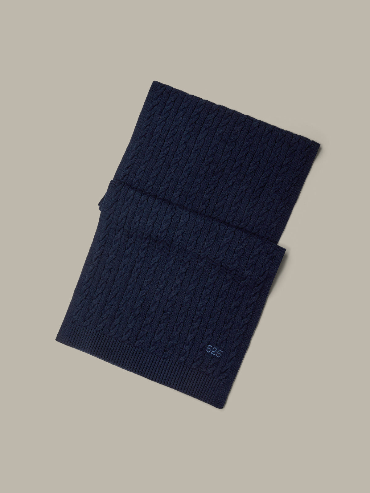 Dark blue knitted scarf on a beige background