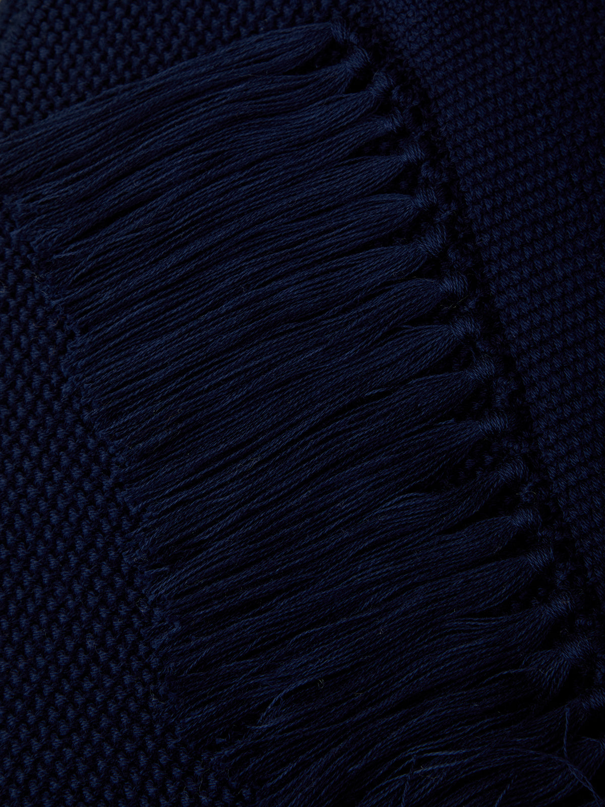 Close-up of a dark blue fabric with fringes