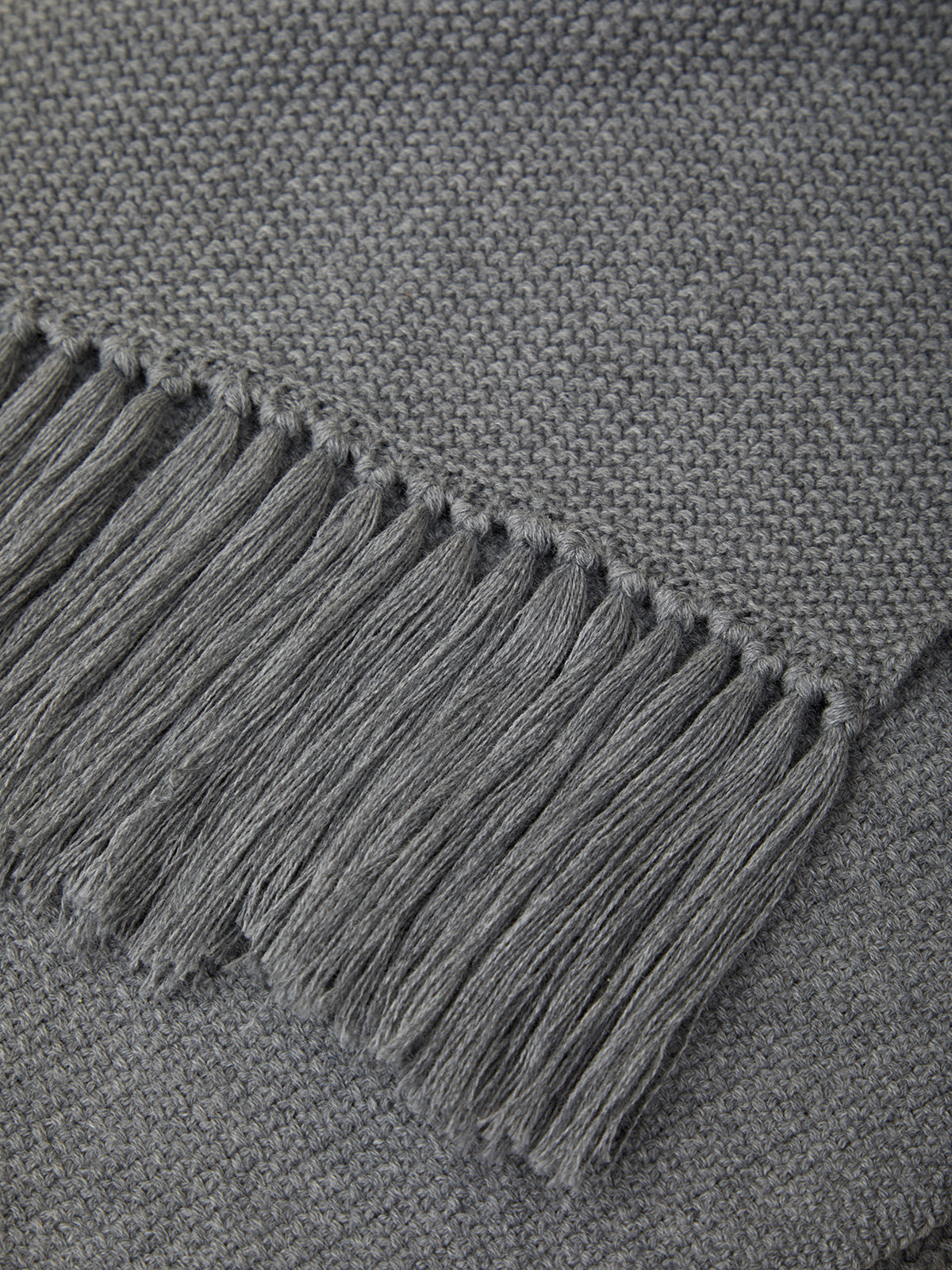 Gray fabric with fringed edge on a textured gray background