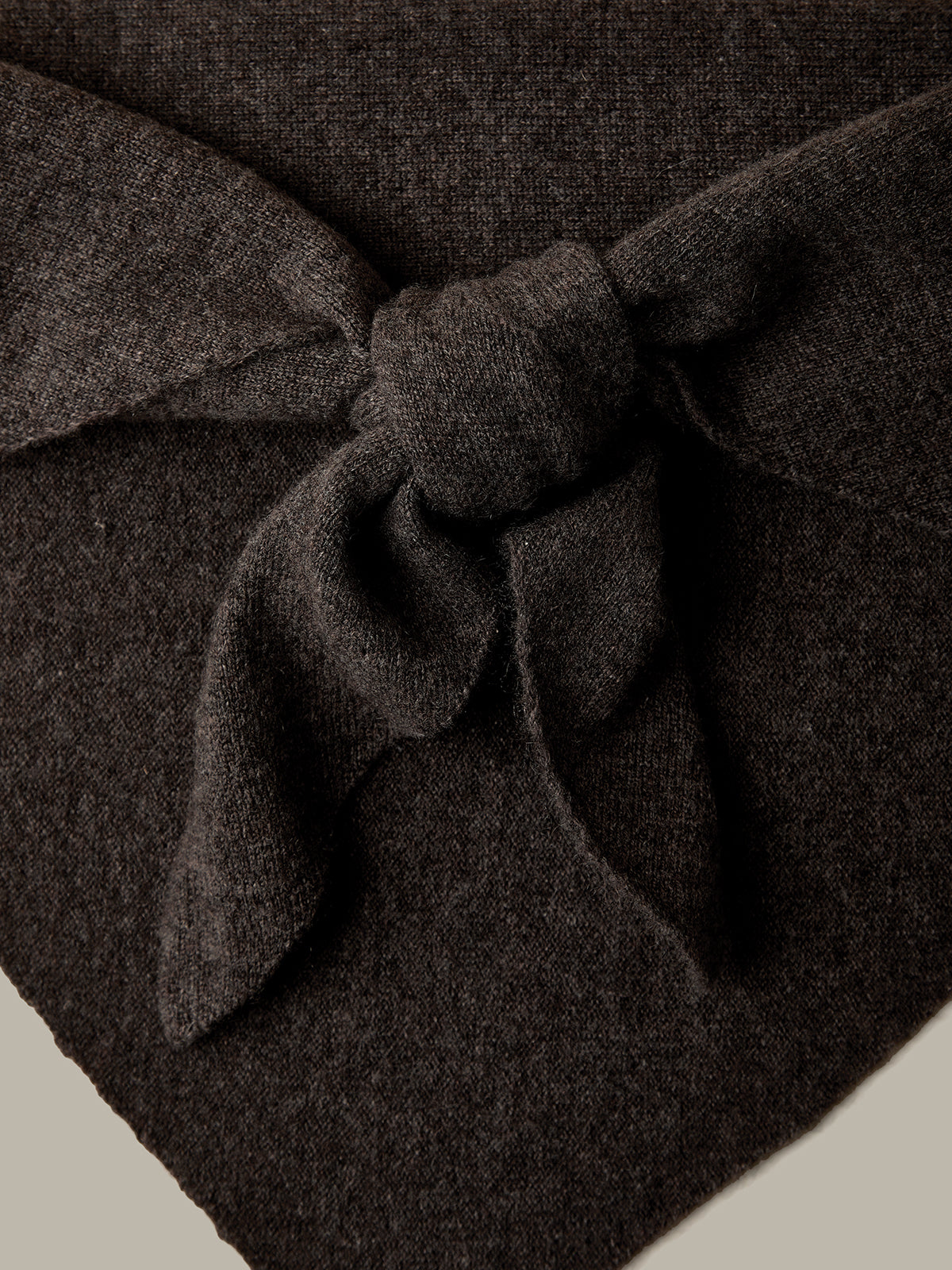 Dark brown fabric with a knot on a beige background