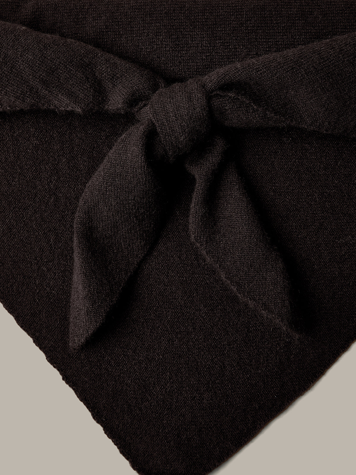 Dark brown fabric with a knot on a beige background
